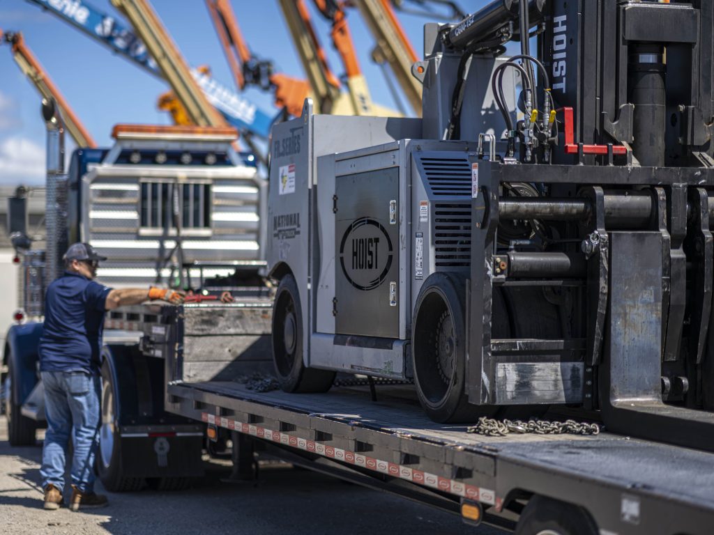 Specialized Hauling loading forklift on a trailer at National Lift Truck