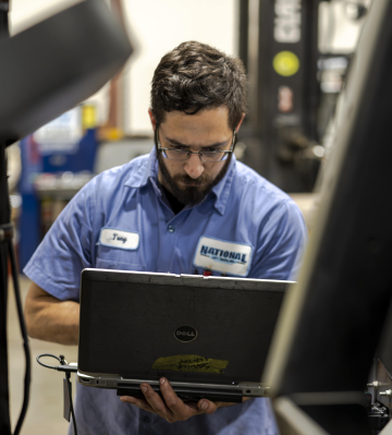 technician at National Lift truck sourcing forklift parts on his computer