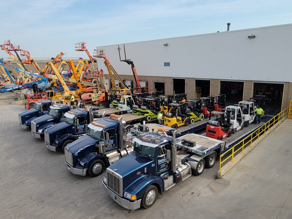 National Lift Truck facility in Chicago with trucks loaded with forklifts and aerial lifts for delivery